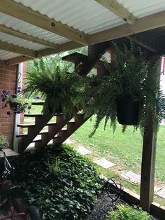 a bicycle is parked under a porch with plants growing on the railing and in front of it