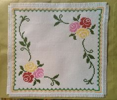 a cross stitched square with flowers on it