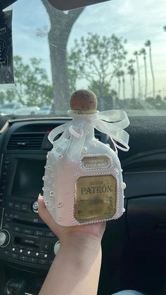 someone is holding up a bottle in their hand that says patron on the front and back