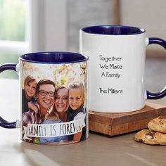 two coffee mugs sitting next to each other on a table with cookies and cookie