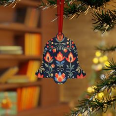 a bell ornament hanging from a christmas tree in front of a bookshelf