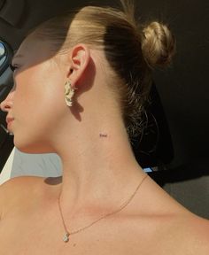 a woman in a car with her back to the camera, wearing earrings