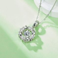 An eye-catching round moissanite dances with ease at the center of this appealing women's necklace, expressing your unstoppable love. Additional round gem set in sterling silver frame the center. Features Moissanite was originally found in meteorites(Chemical name: Silicon Carbide). It was first discovered in 1893, while a scientist was examining meteor samples from a crater in Arizona. After many years, the experts has been recreated moissanite in the laboratory, that make the gemstone with fri