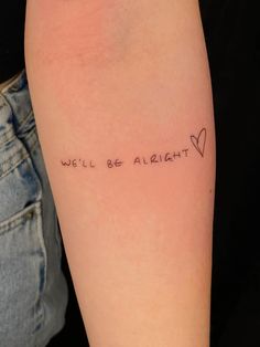 a woman's arm with the words will be alright written on it and a heart