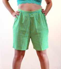 This is a super cute pair of 60s vintage mod checkered shorts! They're blue and yellow checked cotton, which appears mostly green overall when viewed from a distance. They are a Bermuda shape with a high waist, a 0.75" wide waistband and two sliding tabs at the back sides that adjust with four buttons. They do not have pockets, they are shaped with front and back darts, and they close with a 7" long yellow nylon side zipper and a pearl button on your left side. They are in good clean condition overall with a 1.25" hand stitched repair on the center horizontal crotch seam, please see the close up photo of this repair. No other wear, flaws or issues noted. The label says "S.S. Kresge Co., Quality Guaranteed, 100% Cotton, Wash 'N Wear, 18, Made in Japan." The S.S. Kresge stores became K-Mart Retro Cotton Bottoms With Short Length, Retro Cotton Shorts, Retro Knee-length Shorts For Summer, Retro Summer Shorts, Retro Shorts For Spring, Retro Fitted Shorts For Summer, Retro Plaid Bottoms For Spring, Vintage Shorts With Short Inseam For Summer, Gingham Cotton Shorts