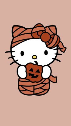 hello kitty holding a pumpkin in her hand and wearing a knitted scarf on top of it