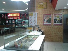 the inside of a fast food restaurant with menus on the wall and tables in front