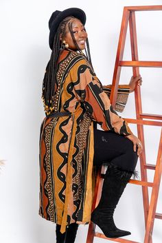 Embrace the timeless elegance of our handcrafted Bogolan kimono, made from traditional African fabric. This standard-size kimono offers both comfort and style with its unique patterns and natural dyes. Lightly structured yet flowing, it is perfect for any occasion, whether you're dressing casually or looking to make a statement. Each piece is a true homage to Malian craftsmanship, making your outfit as unique as you are. Wear a piece of African history and culture while staying effortlessly stylish. Brown Kimono With Kimono Sleeves For Fall, Fall Kaftan With Kimono Sleeves, Traditional Open Front Fall Kimono, Traditional Wrap Kimono For Fall, Bohemian Brown Kimono For Fall, Bohemian Brown Kaftan For Fall, Brown Bohemian Kaftan For Fall, Brown Long Sleeve Kaftan For Fall, Traditional Brown Kimono For Fall