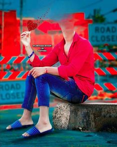 a woman in red shirt and blue jeans sitting on concrete with strawberries flying out of her hand