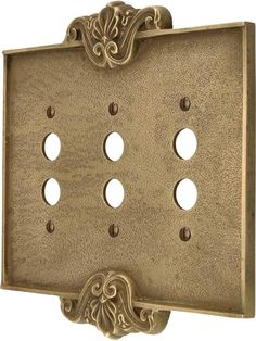 an ornately decorated metal switchplate with four holes