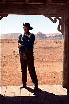 a man wearing a cowboy hat standing in an open doorway