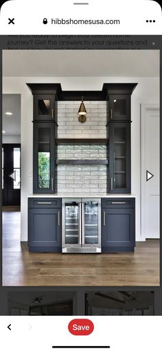 an empty kitchen with black cabinets and stainless steel appliances in the center, along with wooden floors