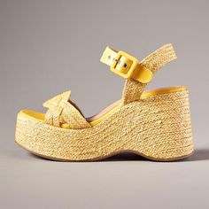 Step into summer with these vibrant yellow open toe ankle strap sandals featuring a chic raffia-wrapped heel and platform design, perfect for adding a touch of sunshine to any outfit. Color: Yellow Heel Type: Block heel Heel Height: 4'' / 100 mm approx Platform Height: 1.5'' / 38 mm approx Product measurements were taken using size 8. Please note that measurements may vary by size. Toe: Open toe Raffia-wrapped heel design Adjustable buckled ankle strap design Handcrafted US sizing. Fits true to size. Yellow High Heel Sandals For Summer, Chic Sandals With Wooden Heel And Straw Material, Yellow Summer Wedge Sandals With Open Heel, Yellow Open Toe Wedge Sandals For Summer, Chic Straw High Heel Sandals, Summer Platform Espadrilles With Ankle Strap, Chic Yellow Leather Wedge Sandals, Yellow Platform Heels For Summer, Straw Sandals With Heel And Ankle Strap