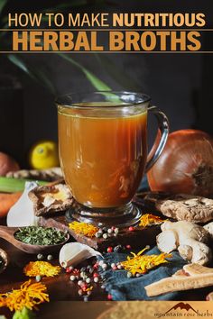 a glass cup filled with liquid surrounded by herbs