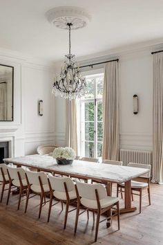 a dining room table with chairs and a chandelier