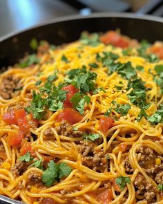 a skillet filled with spaghetti and meat topped with parsley