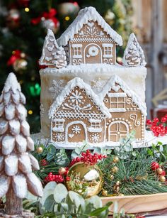 a gingerbread house is on display in front of a christmas tree and other decorations