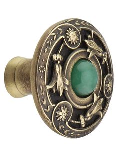 an antique style door knob with a green stone in the center and flowers on it