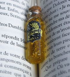 an open book with a small glass bottle on it