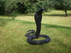 a black snake statue sitting in the grass