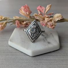 I made this ring with silver precious metal clay casting it from a mold I made of an antique button. The button depicts a Scottish thistle within a textural diamond shaped frame. Once the clay is fired in my kiln it becomes solid silver and the rustic thistle image is enhanced by the painstaking layering of techniques: burnishing, oxidizing, buffing away surface oxidation, then burnishing again and finally hand polishing. Finally, I set the moonstone in it's bezel frame. The Scottish thistle is a noble flower, symbolizing devotion, bravery, determination, and strength. It represents overcoming adversity and has been renowned in Scotland as the national emblem and the symbol of Scotland's ancient order of chivalry known as "The Order of the Thistle". In magical practice thistles have the po Heirloom Style Silver Engraved Ring With Gemstone, Heirloom Silver Engraved Ring With Gemstone, Heirloom-style Silver Engraved Ring With Gemstone, Handmade Heirloom Sterling Silver Moonstone Ring, Handmade Heirloom Moonstone Ring In Sterling Silver, Hand Forged Silver Heirloom Jewelry, Heirloom Hand Forged Silver Jewelry, Antique Silver Engraved Ring With Rose Cut Diamonds, Heirloom Silver Moonstone Gemstone Ring