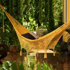 a yellow hammock sitting on top of a wooden floor