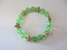 This is a Green Star Beaded Bracelet. It would make a cute gift for a little girl's Birthday. They make cute party favors. It would make a cute addition to a little girl's outfit. It has six green star beads. It has green 8mm faceted beads. It was made with .8mm sturdy stretch string. I tie it several times to prevent breakage. It fits girls ages 4-7. It stretches to fit on the wrist. All items are ready to be shipped I do combined shipping. Items ship in 2-5 business days. Check out more items Green Star-shaped Party Jewelry, Adjustable Green Charm Bracelet For Party, Adjustable Stretch Bracelet With Star Charm As Gift, Adjustable Beaded Bracelets With Star Charm For Gift, Adjustable Bracelets With Star Charm, Beaded Bracelets With Star Charm For Gifts, Adjustable Bracelets With Star Charm And Round Beads, Adjustable Star-shaped Party Bracelets, Star-shaped Beaded Party Bracelets