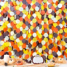 an orange, yellow and brown polka dot curtain hanging from the side of a table