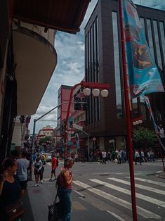 many people are walking on the street near tall buildings