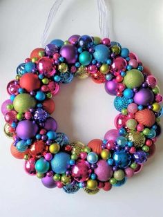 a colorful christmas ornament wreath hanging on a wall