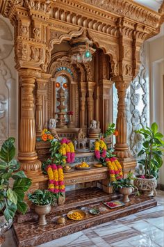 an ornate wooden shrine with flowers on the floor and potted plants next to it