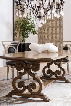 a dining room table with chandelier hanging from the ceiling