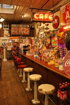 the inside of a restaurant with several tables and stools lined up against the wall