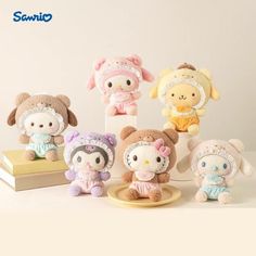 several small stuffed animals sitting on top of a wooden table next to a stack of books