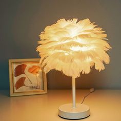 a lamp that is sitting on top of a table next to a picture and an empty frame