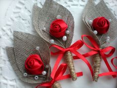 three boutonniers with red roses and pearls on them are sitting on a lace doily