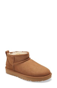 An ultrashort shaft adds a twist to this abbreviated version of a classic UGG boot. The style delivers extra comfort with a lining crafted from both genuine shearling and UGGplush, a moisture-wicking textile made from a wool-rich blend but crafted to feel and wear like genuine shearling. 1" platform (size 9) 4" shaft Pull-on style Treadlite by UGG outsole is lightweight and flexible Leather upper/genuine shearling and UGGplush wool-blend lining/synthetic sole Shearling may be sourced from Australia, Ireland, Spain, the UK or the USA. See packaging for confirmed country of origin Imported Classic Boots Woman, Expensive Outfits, Ugg Ultra Mini, Clothing Board, Ugg Boot, Chelsea Boot Women, Classic Ugg Boots, Mini Classic, Waterproof Hiking Shoes