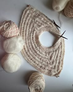 some balls of yarn and needles on a table