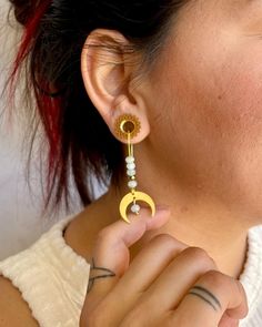 a woman is wearing some kind of earring that has a crescent and star on it