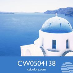 a blue and white building with the ocean in the backgroung is an advertisement for cisicolors com