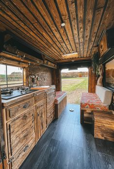 the inside of a small cabin with wood flooring and wooden cabinets on both sides