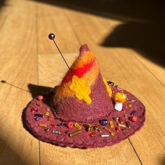 a felt hat with pins and beads on it