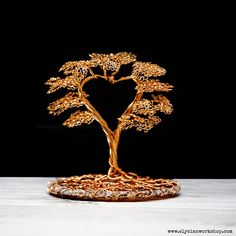 a golden bonsai tree is displayed on a table