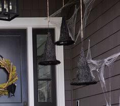 halloween decorations hang from the front door of a house with spider webs on it