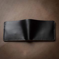 Ever have a leather wallet you can't stop talking about?You will know the difference our craftsmanship makes as soon as you hold this wallet. Our classic design meets attention to detail unparalleled by any department store wallet. Flawless hand-stitching, authentic real leather smell, and backed by a lifetime guarantee. Take satisfaction in knowing that this wallet will be the last one you will ever buy.Full-grain Horween leather means your wallet will develop character and patina. We hand-sew Black Leather Rectangular Wallet, Black Leather Wallet For Daily Use, Black Bifold Wallet For Daily Use, Black Leather Wallet With Rfid Blocking, Black Smooth Grain Wallet As Gift, Classic Leather Wallet With Leather Lining, Leather Bifold Wallet With Coin Pocket, Leather Bifold Wallet With Rfid Blocking, Black Leather Wallet As Gift