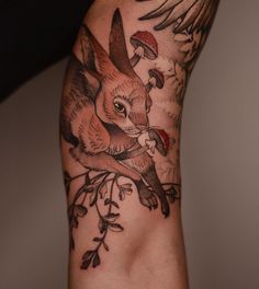 an arm with a rabbit and mushrooms on it