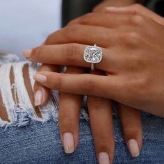 a close up of a person's hand with a engagement ring on their finger