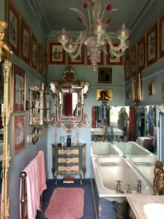 a bath room with a sink a mirror and a chandelier in it's corner