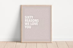 a framed poster with the words sixty reasons we love you in white and pink on it