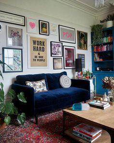 a living room with blue couches and pictures on the wall above it's coffee table